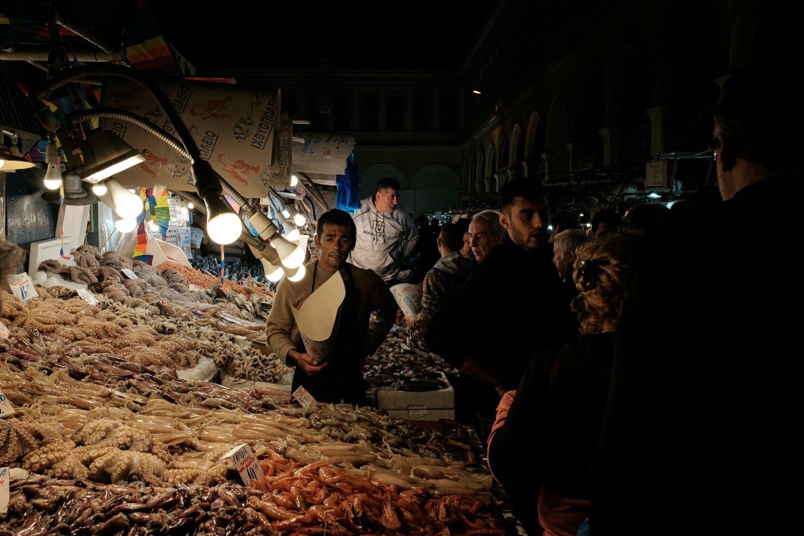 A night fish market under bare bulbs